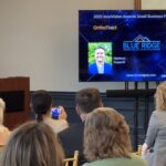 A member of the SCRA presentation team stands behind the podium to present the small business finalists of the Meet the Finalists event