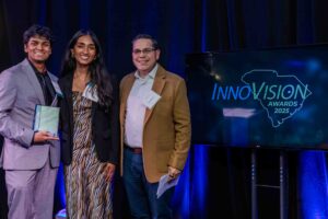 Shrihan Ganesh Babu and Sanjana Tripuraneni of CuffWay stand with Elias Bustos of Harvest 21 as they accept the award for Technology Development at the 2025 InnoVision Awards 